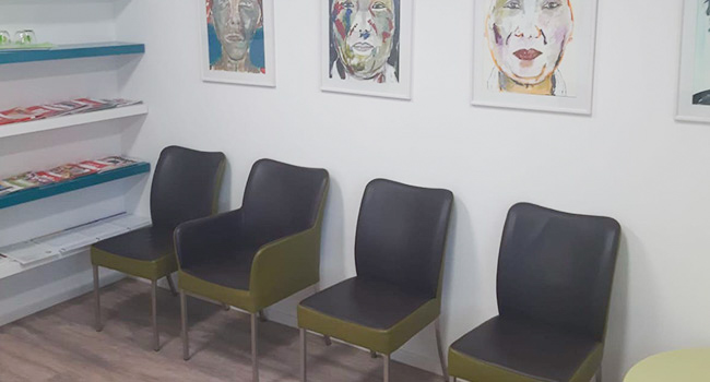 Eingangsbereich einer zahnmedizinischen Praxis mit vier Stühlen